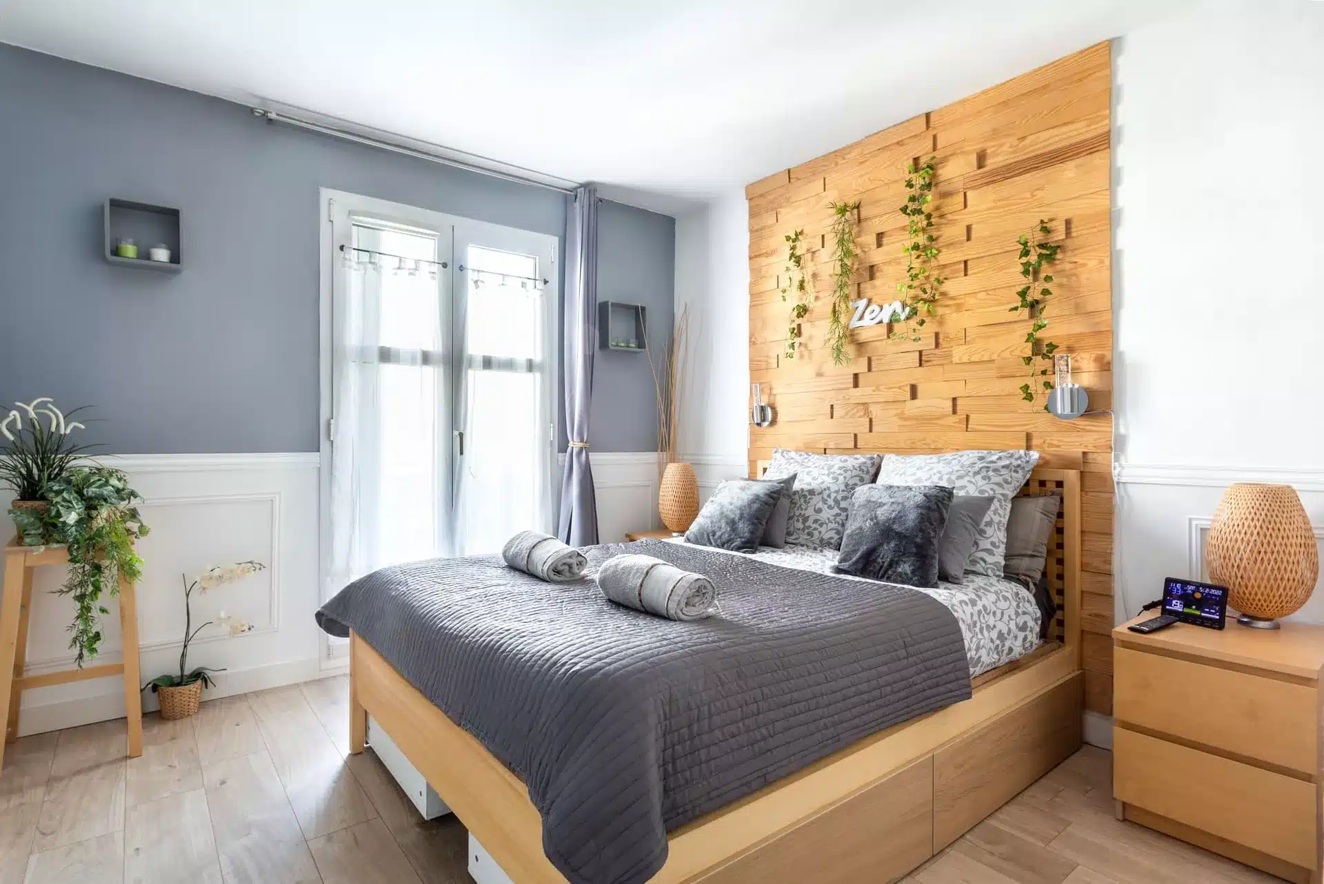 Chambre double cosy avec tête de lit en bois et mur bleu gris, photo location saisonnière Versailles 78000