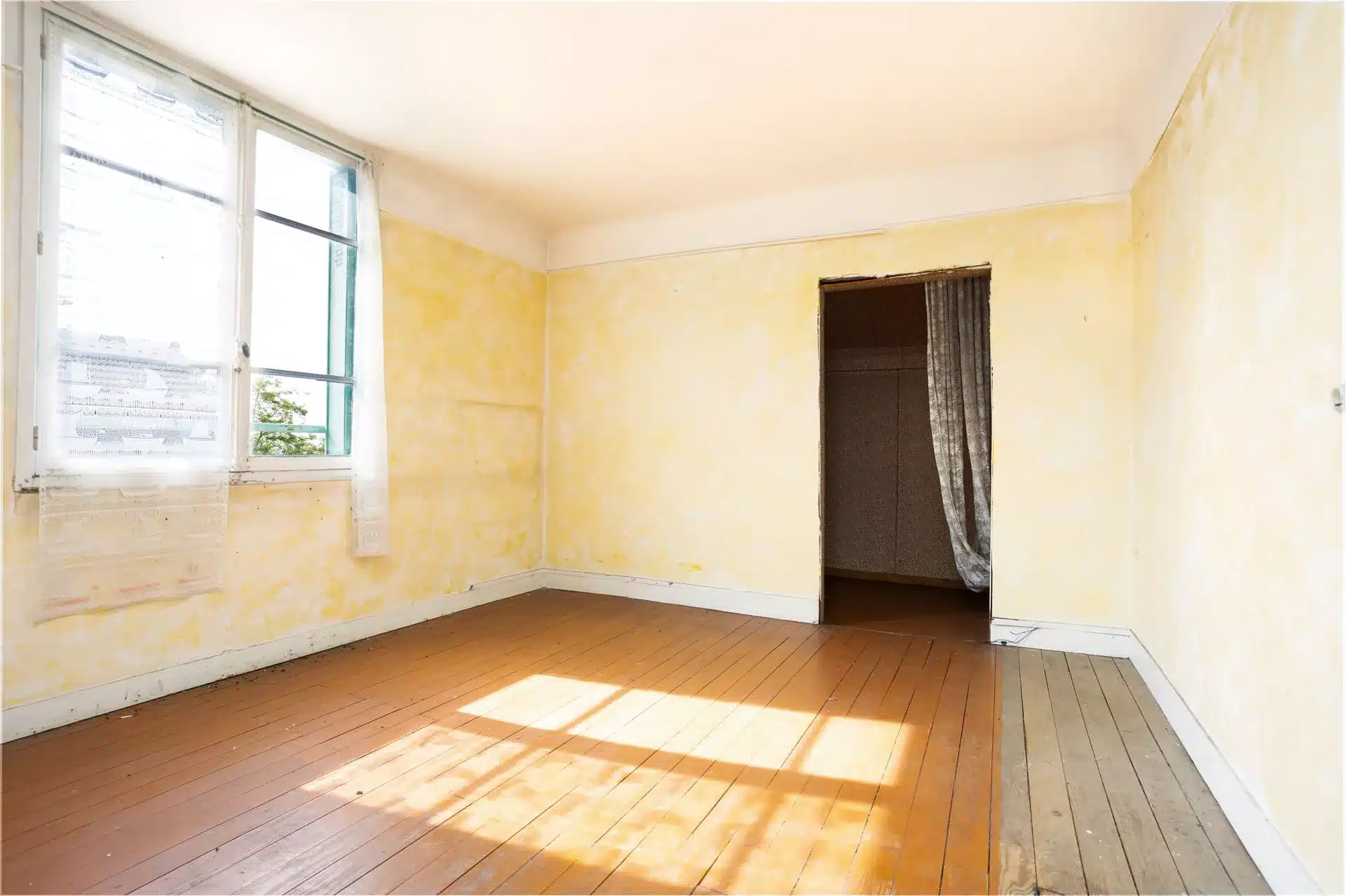 Pièce vide à rénover avec radiateur fonte et papier peint ancien, prête pour simulation 3D