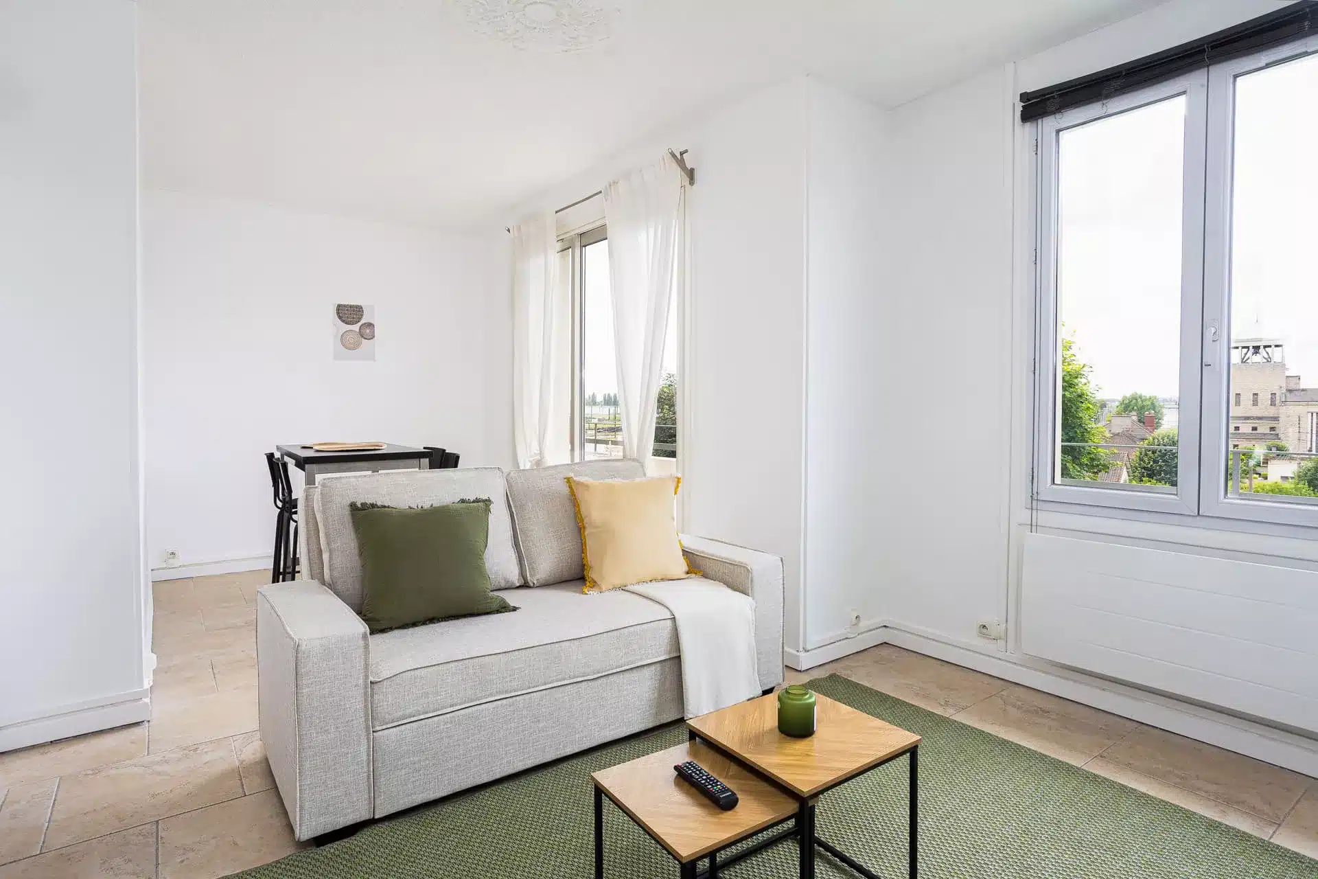 Photographe immobilier salon lumineux avec canapé gris, grandes fenêtres et vue dégagée – appartement à Athis-Mons 91200